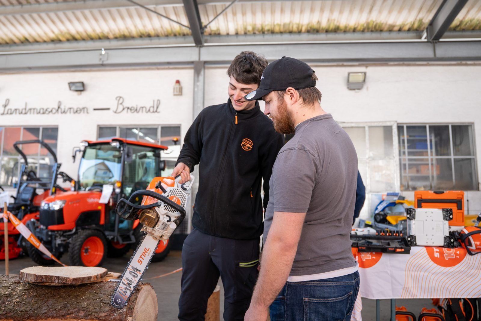Mitarbeiter von Landtechnik Breindl berät einen Kunden zu einer STIHL Motorsäge